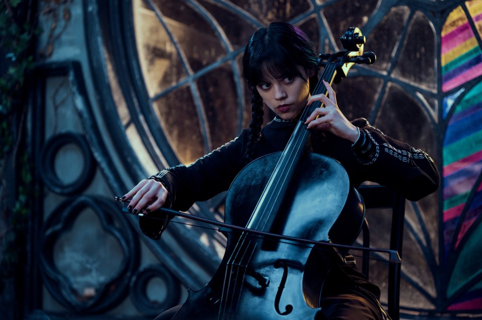 Jenna Ortega as Wednesday Addams playing a cello.