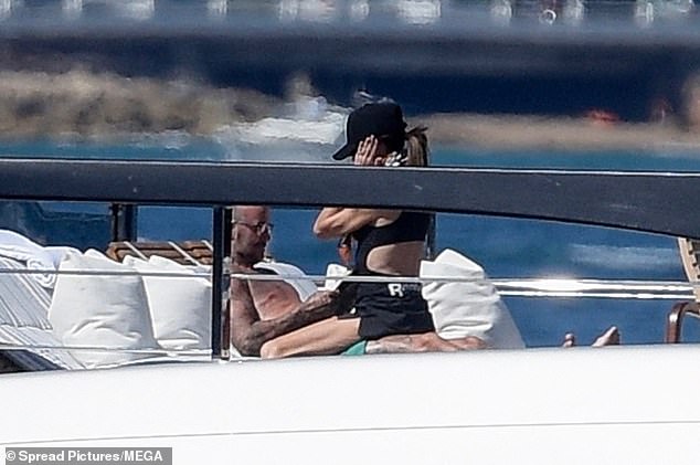 Victoria straddled David as he looked invested in his book