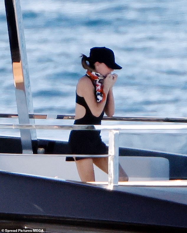 Victoria shielded her face from the sun in a black baseball cap and pattern scarf