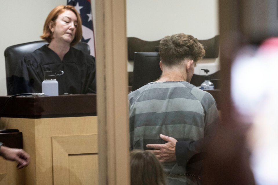 A defendant in a striped jumpsuit at a bond hearing.