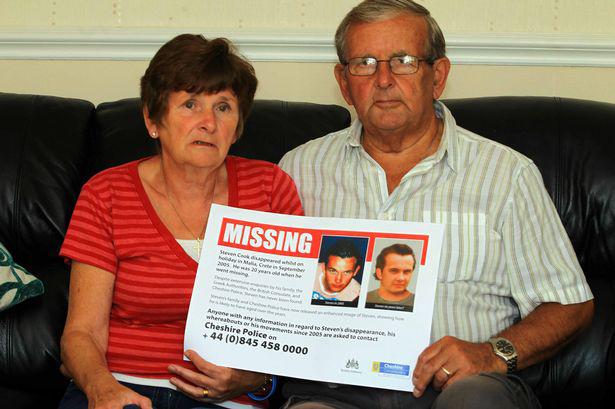 Couple holding missing person poster.