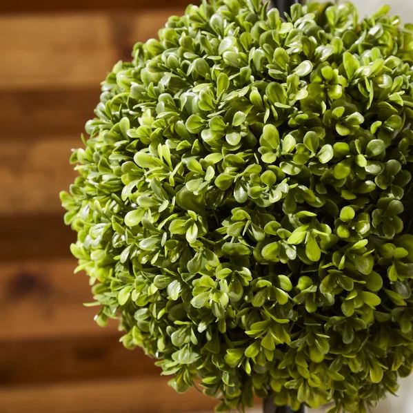Artificial boxwood ball tree in a woven plant pot.