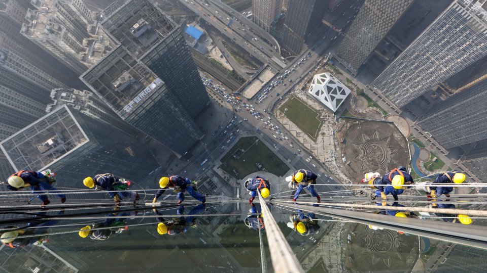 Window washers cleaning the exterior of the Guiyang International Trade Center in China.