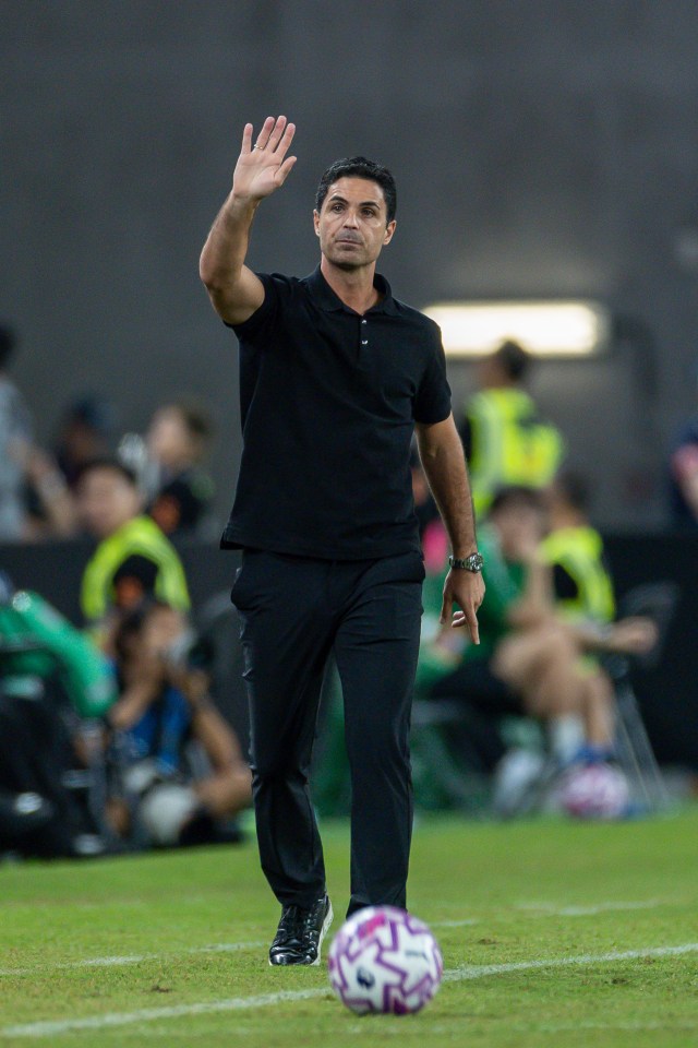 Mikel Arteta waving at a soccer game.