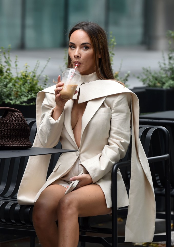 Chelsee Healy, Hollyoaks actress, sits outside drinking from a cup.