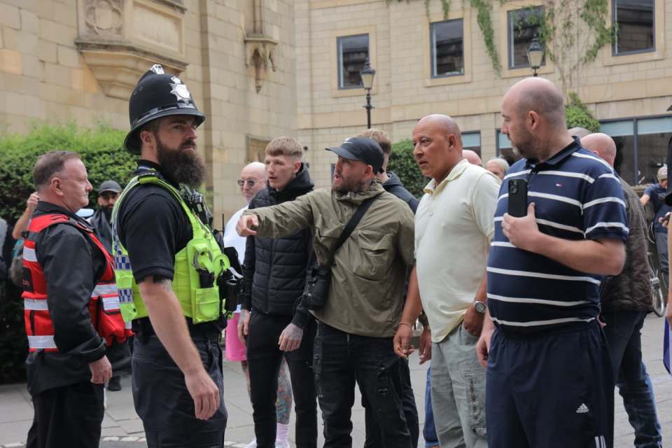 Police officer intervening in an anti-immigrant protest.