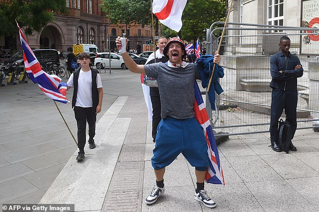 MANCHESTER: A group of protesters are seen holding St George and Union Jack flags