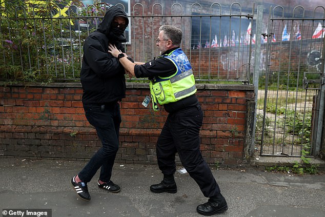 MANCHESTER: A police officer classes with a protester at the rally