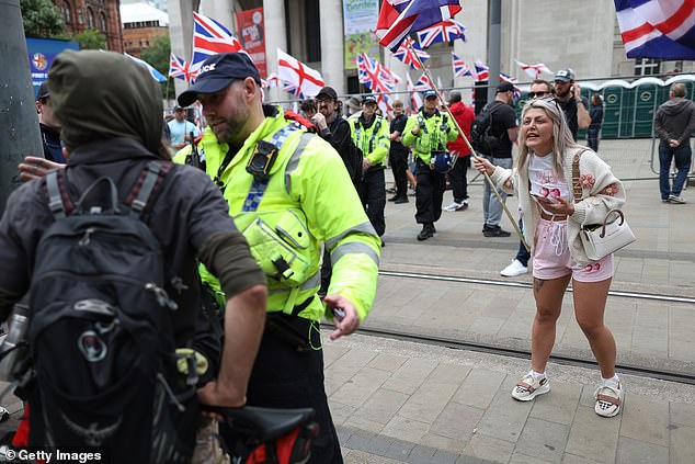 MANCHESTER: Police speak to people as a woman holding a flag gestures during the Britain First March