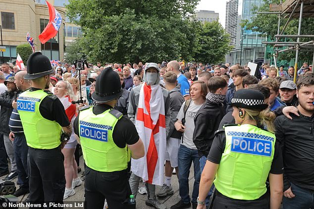 Some anti-migrant protesters waved England football flags as police officers watched on