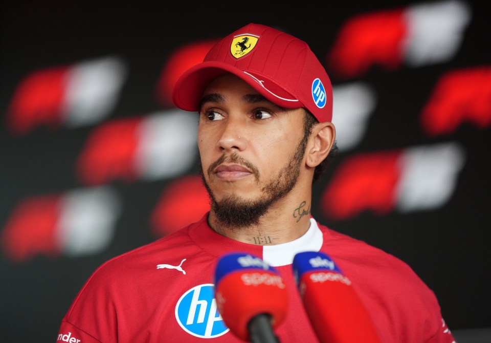 Lewis Hamilton at a press conference wearing a Ferrari cap and shirt.