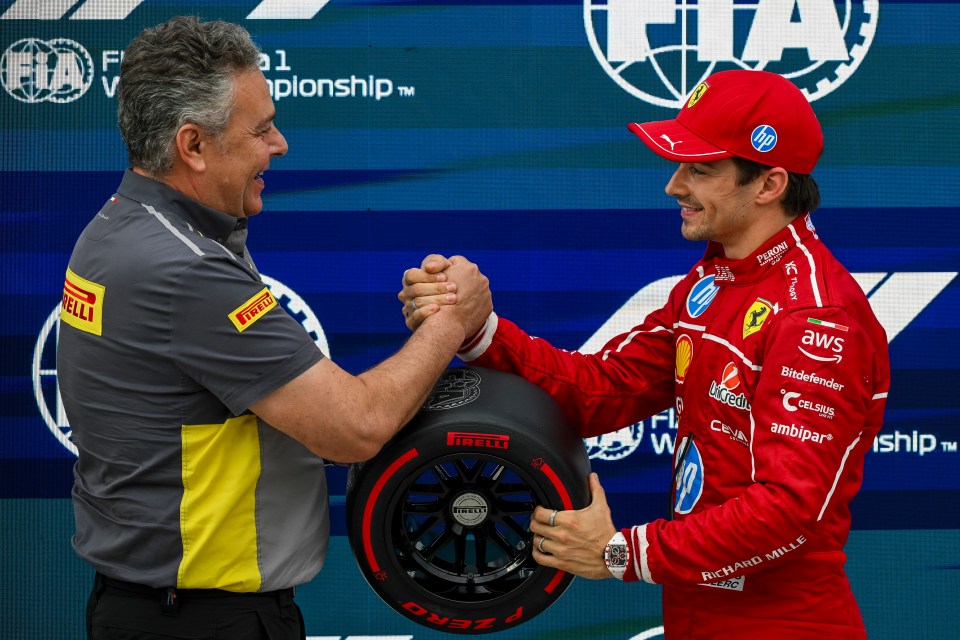 Charles Leclerc shaking hands with Pirelli motorsport director Mario Isola.
