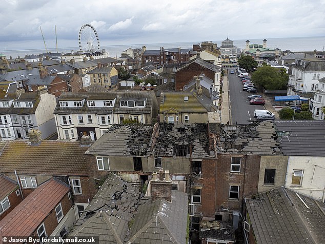 An aerial view looking at the back streets behind the seafront. The tops of broken and burnt down roofs can be seen