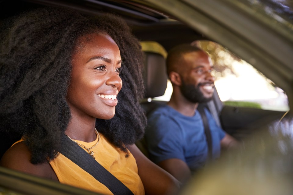 Smiling Black couple on a road trip.