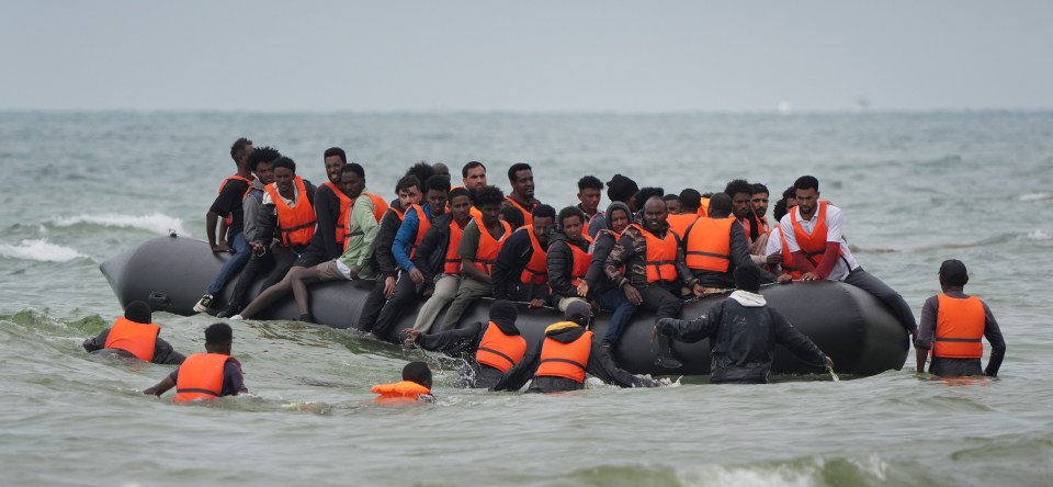 Migrants in a small boat at sea.