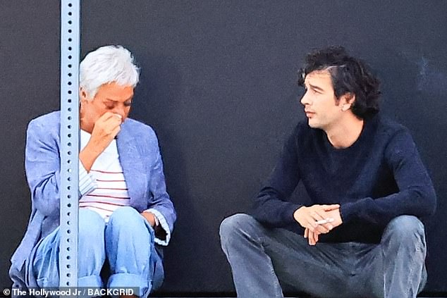 The actress was seen dabbing her eyes with a tissue as she sat on a pavement outside Stella restaurant, with the 1975 front man sitting close by to support her