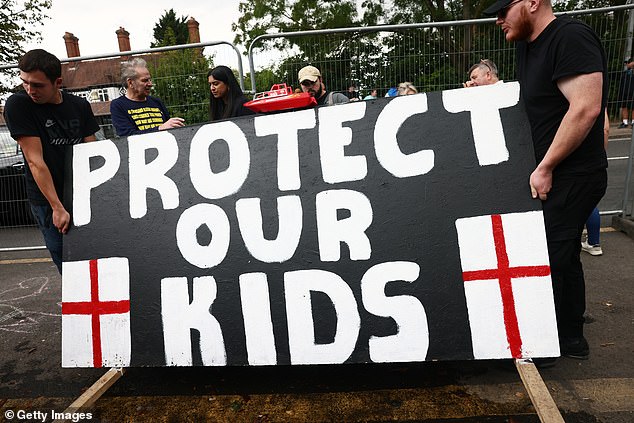 Protesters gather near the Bell Hotel during a protest against the use of the hotel as migrant accommodation on July 27, 2025 in Epping, England