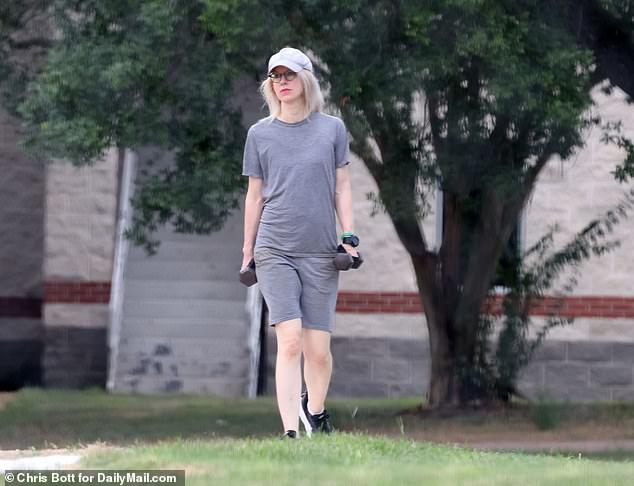 Holmes donned a cap and was seen carrying weights as she exercised