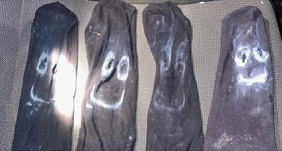 Four socks with painted-on faces.