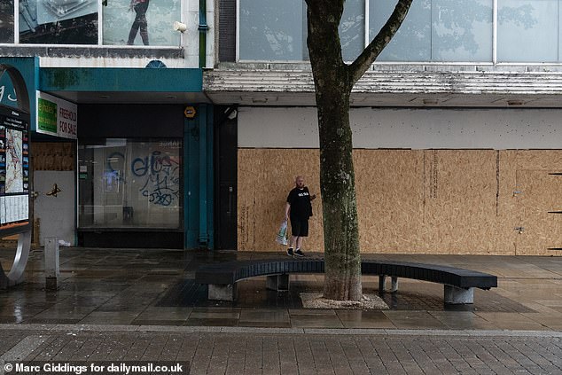 Another boarded up store. Locals say the centre remains empty because people are 'too frightened' to even visit the high street