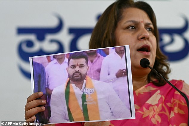 Congress spokesperson Supriya Shrinate shows a photograph featuring JD(S) MP Prajwal Revanna (L) who was summoned for alleged sexual abuse case, at a press conference in Bengaluru on May 1, 2024