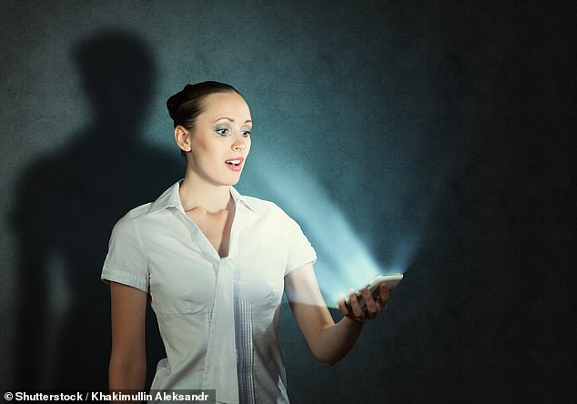 Woman illuminated by the light from her mobile phone