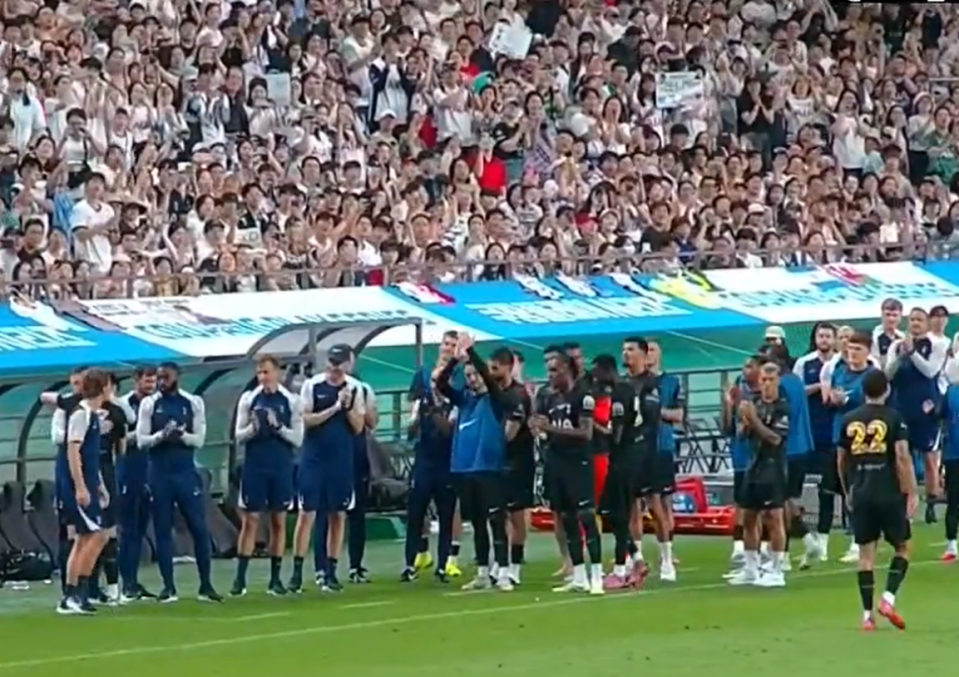 Soccer players and fans at a game.