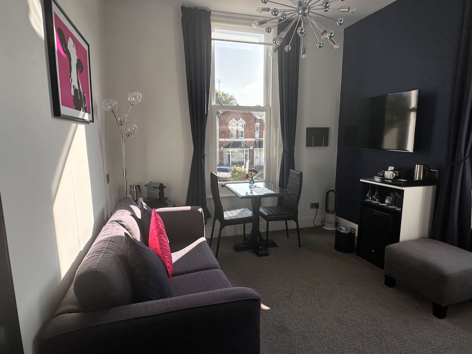 UK's best B&B room with sofa, table, and TV.