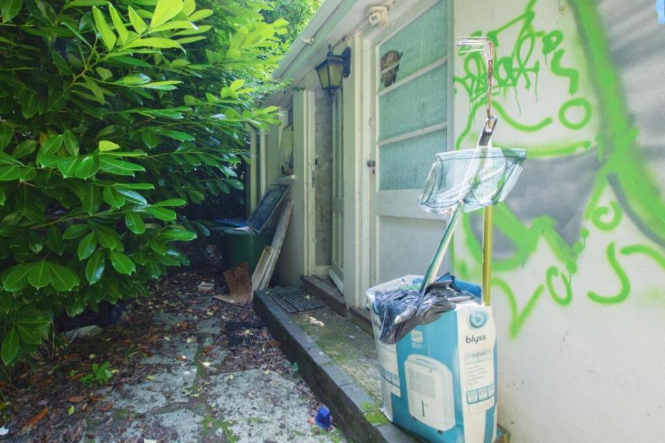 Graffiti-covered exterior of a house needing refurbishment.