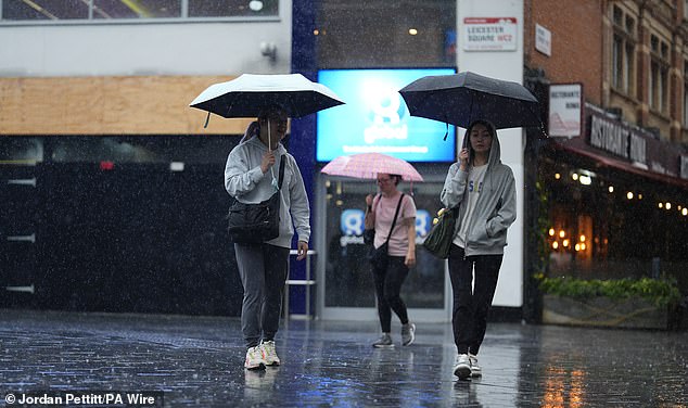 People walking in the morning rain in Leicester Square, central London