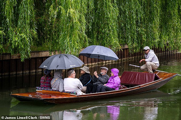 People punting on the river Cam on a wet start to the day on July 31 in Cambridge