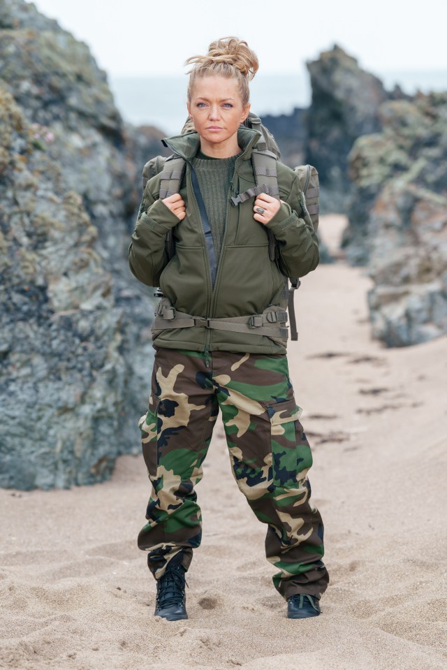 Hannah Spearritt in camouflage clothing and a backpack on a beach.