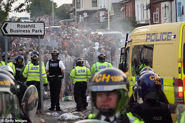 Riot police hold back protesters after disorder broke out in Southport on July 30 - a day after the knife attack