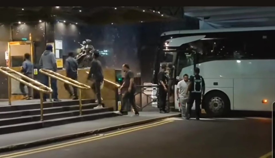 Migrants arriving at a hotel from a bus.