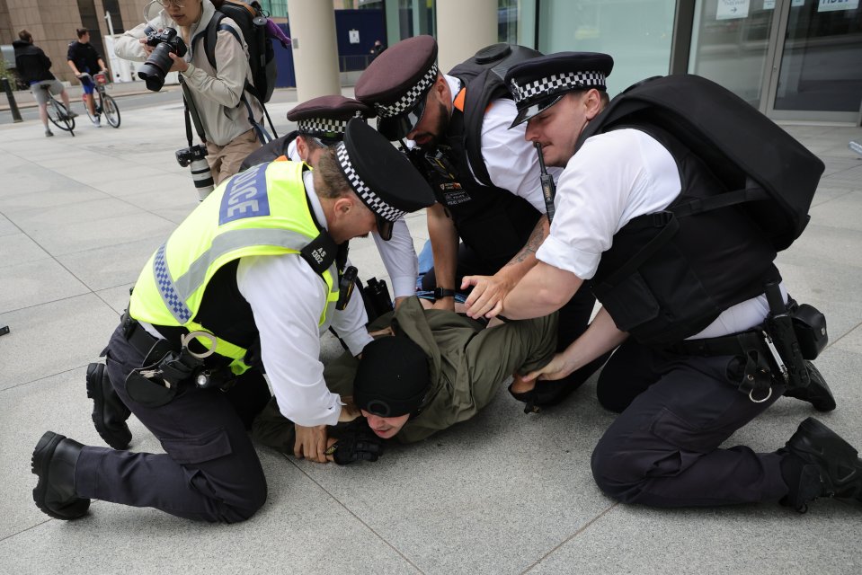 Police officers arresting a protester.