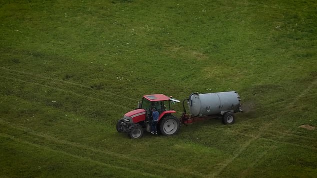 Footage shows the striking moment tractors are let loose on a farm to drive around in circles spraying a brown sludgy-looking liquid in their wake. Pictured: A squatter manages to cling onto the vehicle - but not for long