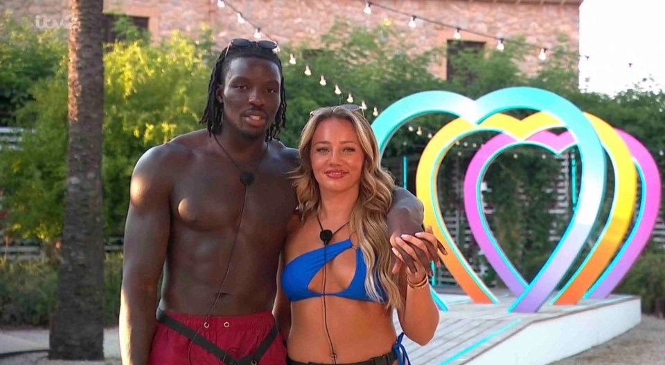 Meg and Dejon from Love Island holding hands.
