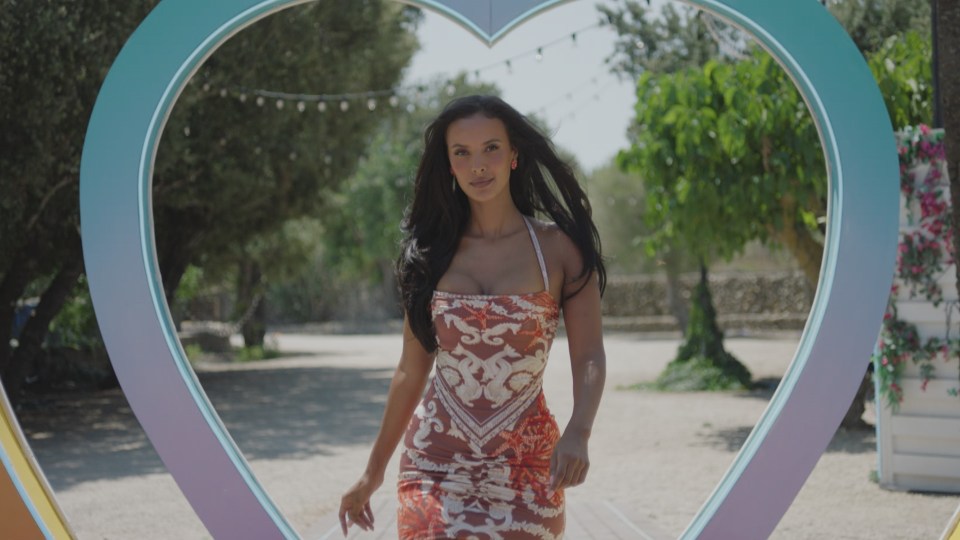 Maya from Love Island walking through a heart-shaped frame.