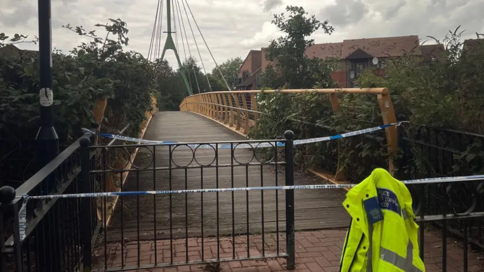 Police tape across a footbridge; a police jacket is visible.