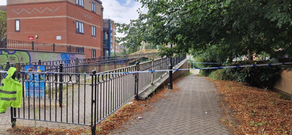 Crime scene near a river, marked off with police tape.