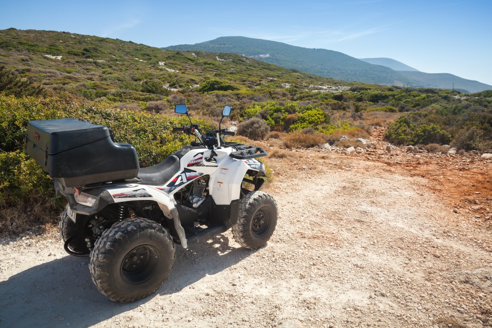 White ATV parked on a dirt road.