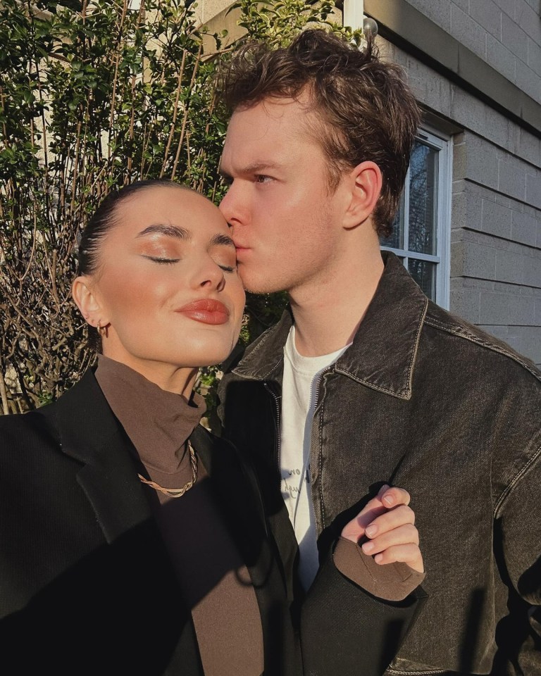 A man kissing a woman on the forehead.