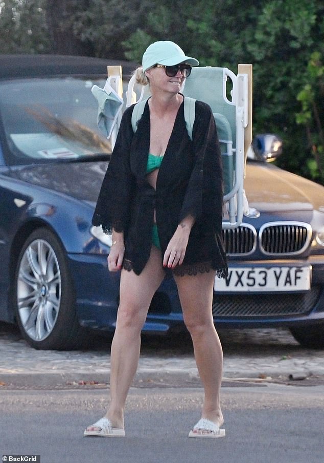 Anne-Marie wore a green bikini with a black beach cover up and sandals