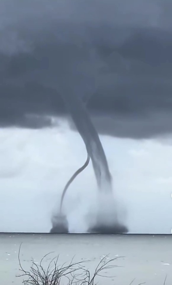 Tornado over water forcing tourists to flee a beach.