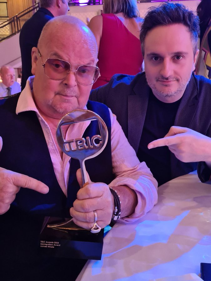 James Whale holding a TRIC Awards 2023 Recognition Award.