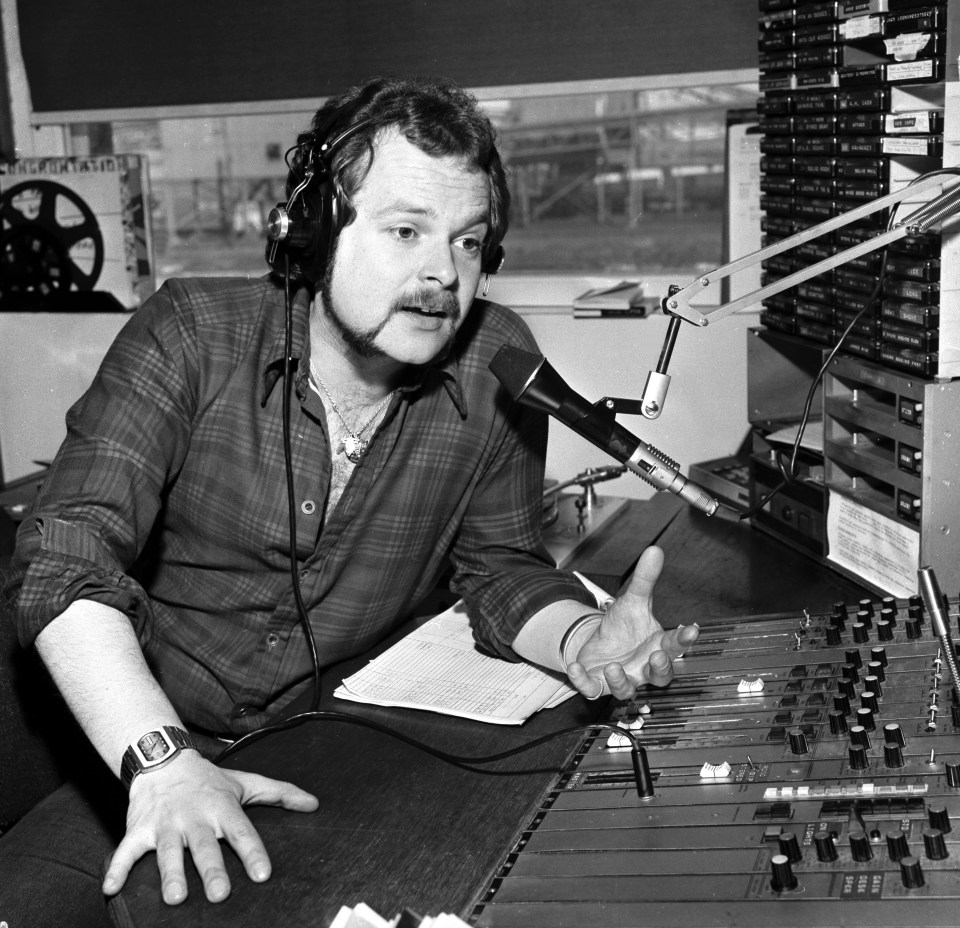 Black and white photo of a DJ at a radio station in the 1970s.