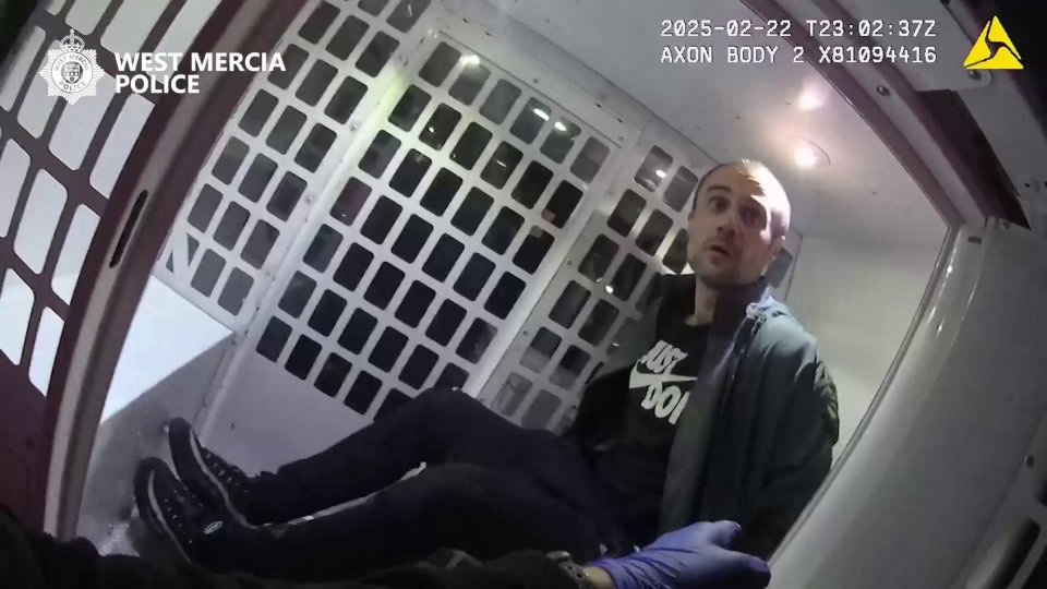 Arrested man in police vehicle.