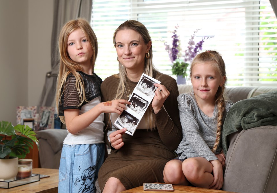 Mother with her two daughters looking at a baby scan.