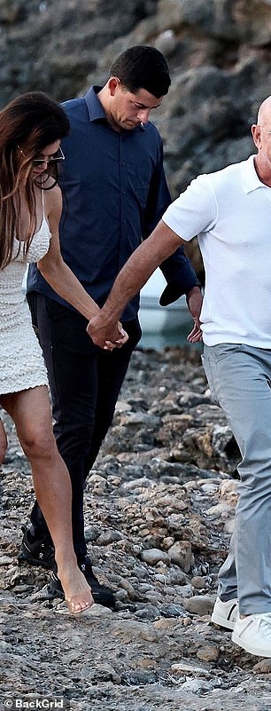 Her husband, 61, kept it simple in a white polo shirt, grey trousers and white trainers, slightly more apt for the rocky shore