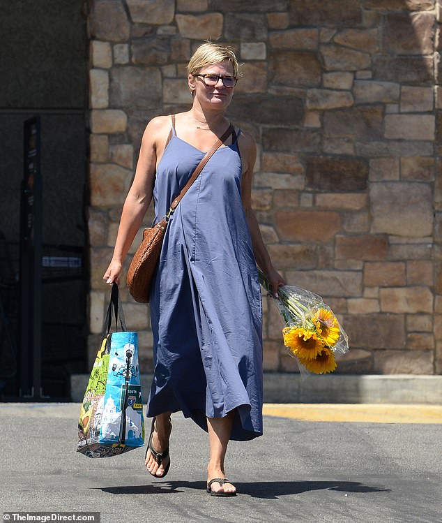 She donned a sleeveless blue midi dress along with black flip flop sandals